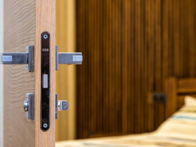 Close-up of a metal door handle and lock on a wooden door